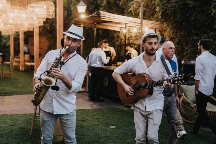 נגנים לאירועים – סקסופון וגיטרה מנגנים בין האורחים בקבלת פנים בגן אירועים
