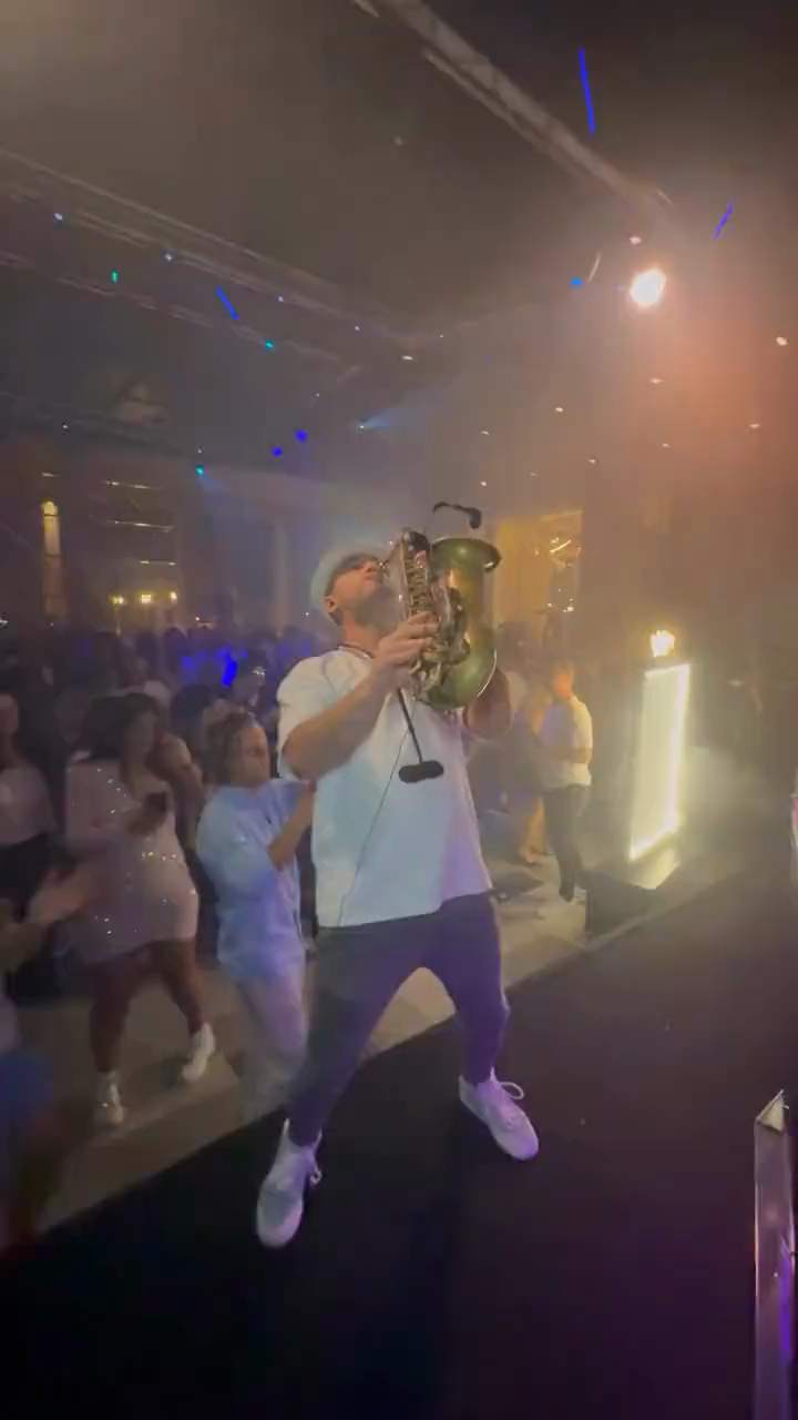 Tal Rudovsky toca el saxofón en el escenario frente a una pista de baile llena – músicos y bandas para eventos en Israel de Musicali