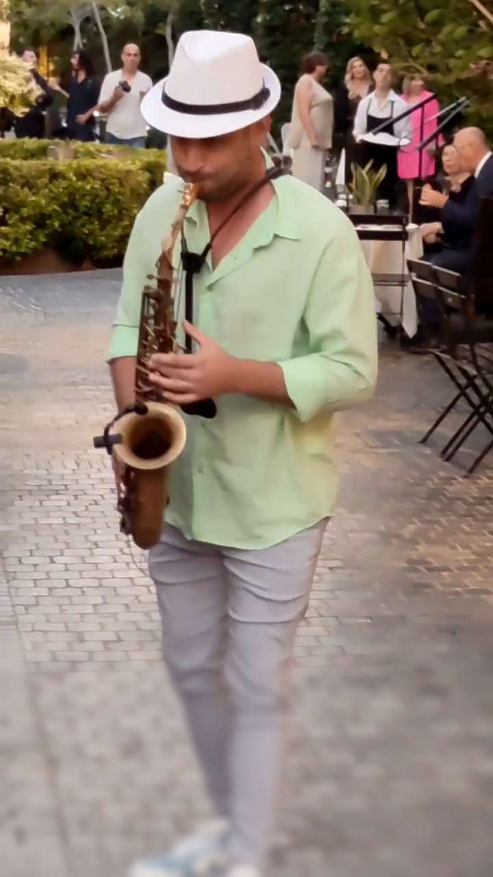 Tal Rudovsky of Musicali plays the saxophone at a reception in a lit courtyard – musicians and bands for events in Israel