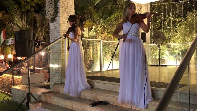 כנריות לחתונה – שתי כנריות בשמלות לבנות מנגנות בקבלת פנים