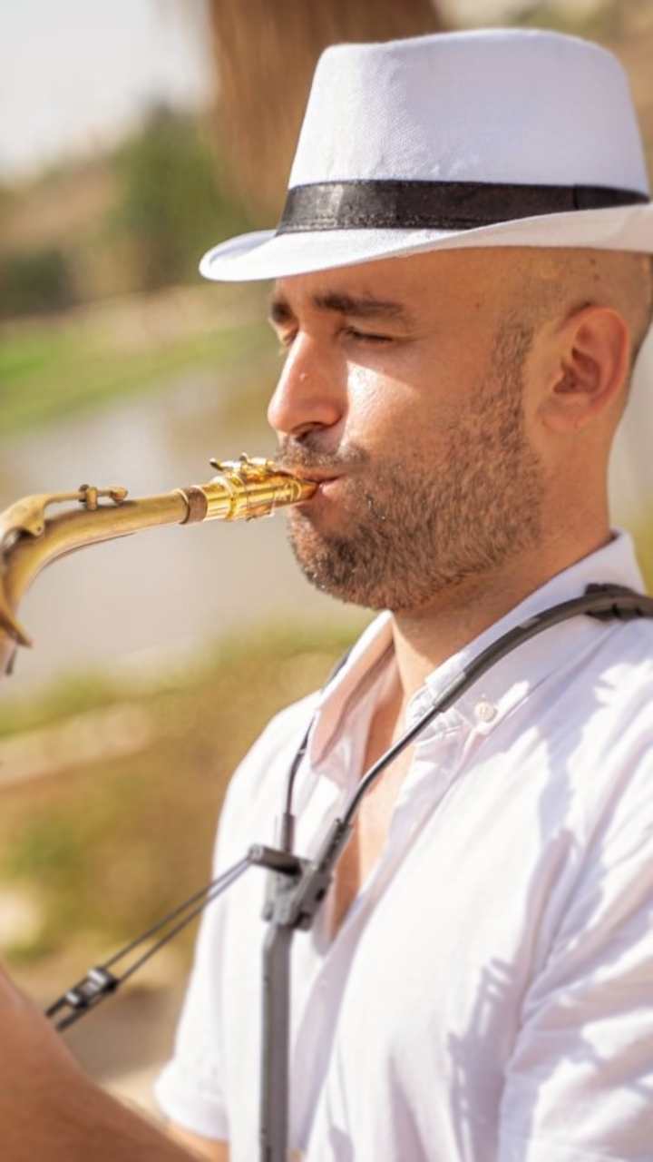 מורה לחליל צד במודיעין – טל רודובסקי מנגן בכלי נשיפה בעיניים עצומות, באור חם בחוץ