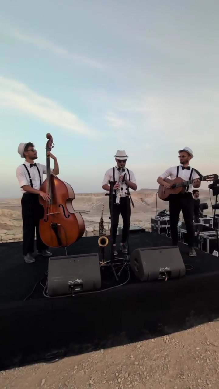 Jazz band for events in Israel – a jazz trio with double bass, guitar and saxophone on a stage in the desert