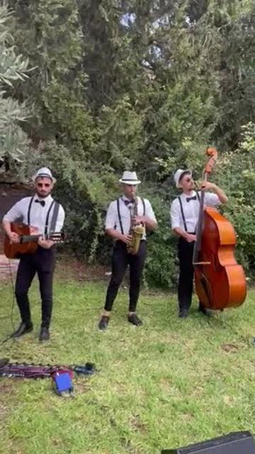 הרכב ג'אז לקבלת פנים – טריו Jazzmen: גיטרה, סקסופון וקונטרבס מנגנים בגן