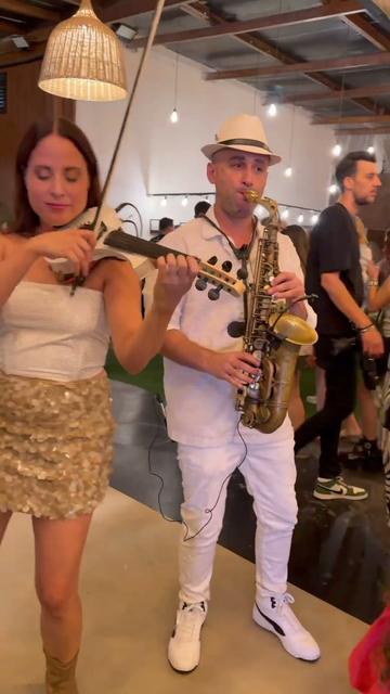 Saxophone et violon pour événements – une violoniste et un saxophoniste jouent sur la piste de danse