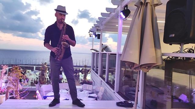 Saxophone Live on DJ – un saxophoniste sur une terrasse de réception face à la mer