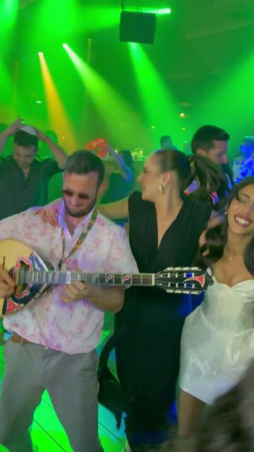 Bouzouki sur la piste de danse – un musicien bouzouki de mariage parmi les danseurs